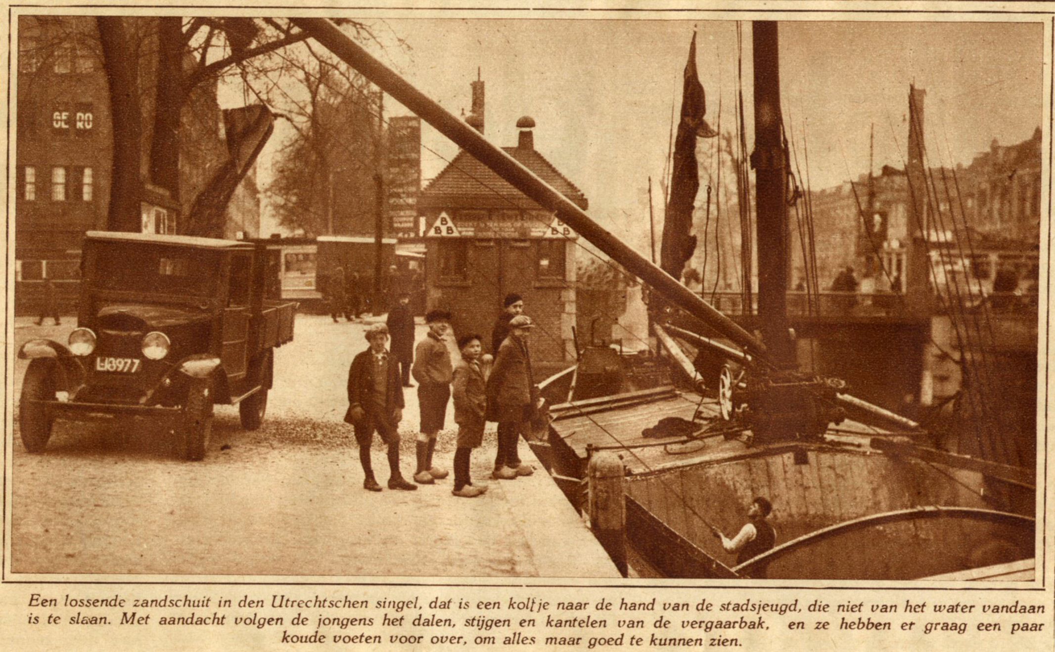 Het lossen van een zandschuit op de Catharijnekade te Utrecht met enkele belangstellende jongens en op de achtergrond de Catharijnebrug 1930 HUA